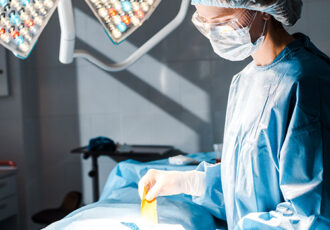 nurse in uniform and medical cap holding strip in operating room